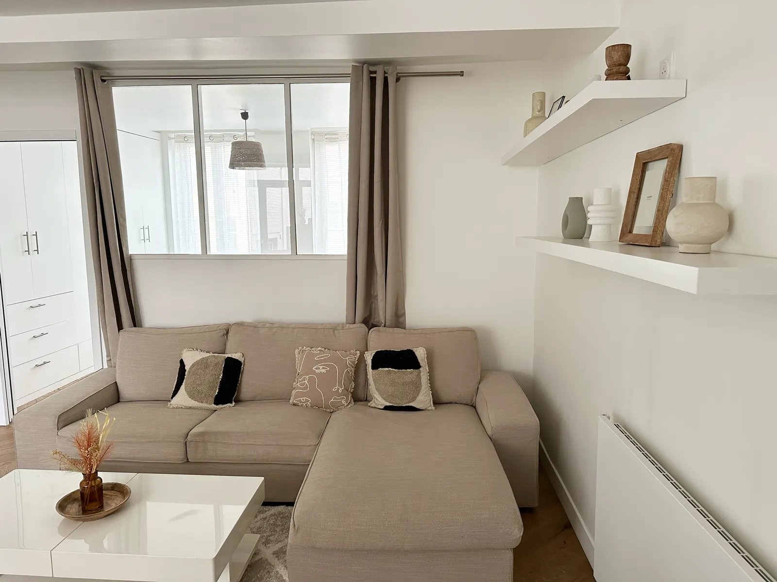 Salon avec verrière intérieure donnant sur la chambre